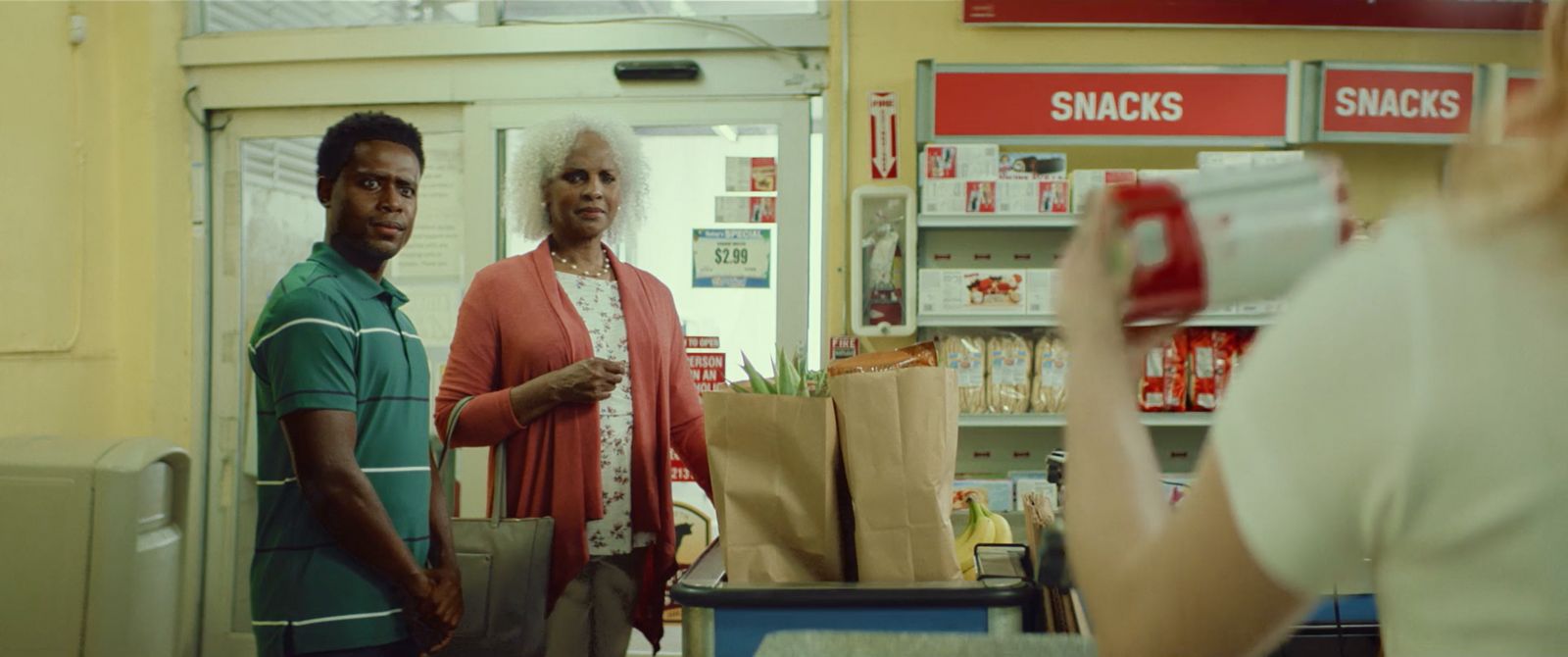 a woman taking a picture of a man in a store