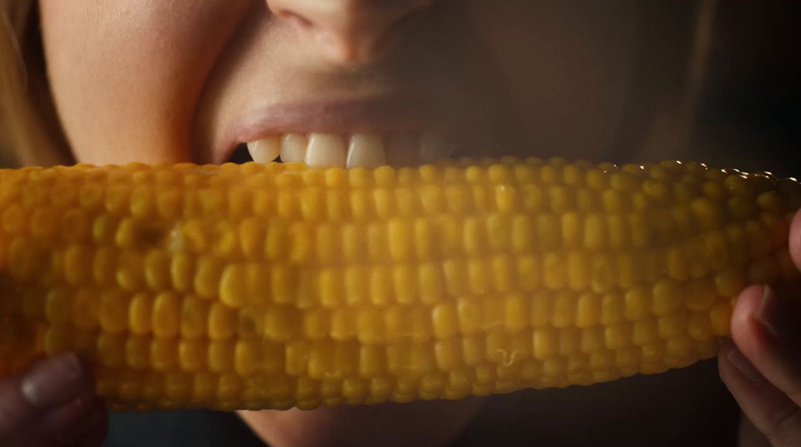 a woman eating a corn on the cob