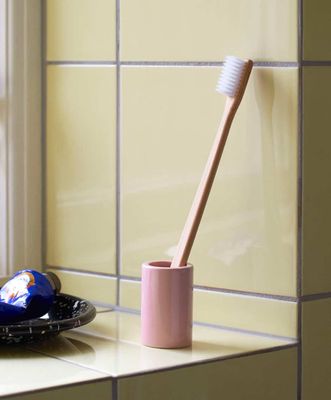 a toothbrush in a cup sitting on a counter