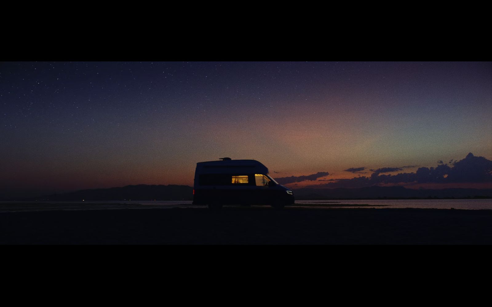 a van is parked on the beach at night