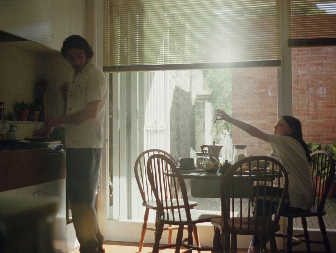 a man standing in a kitchen next to a woman