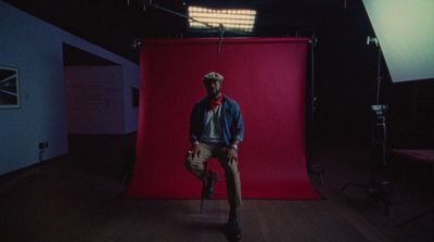 a man standing in front of a red backdrop