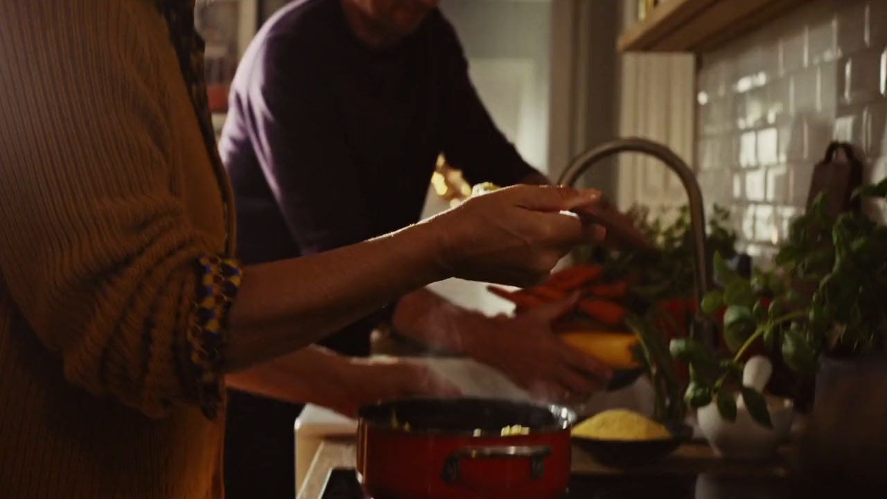 a man and a woman preparing food in a kitchen