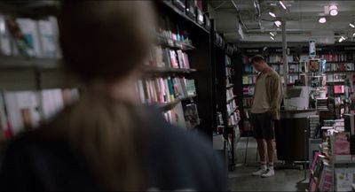 a man standing in front of a bookshelf filled with books