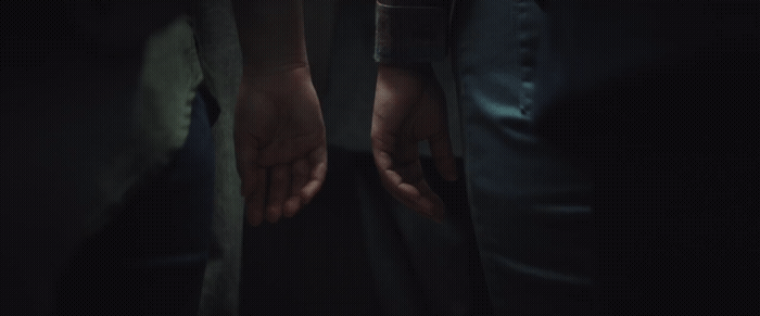 two people holding hands in the dark