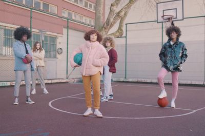 a group of young people standing on top of a basketball court