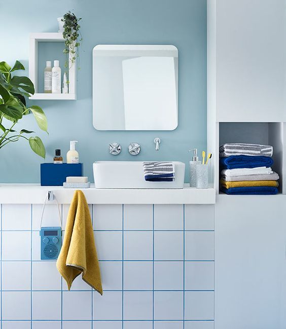 a bathroom with blue and white tiles and a plant