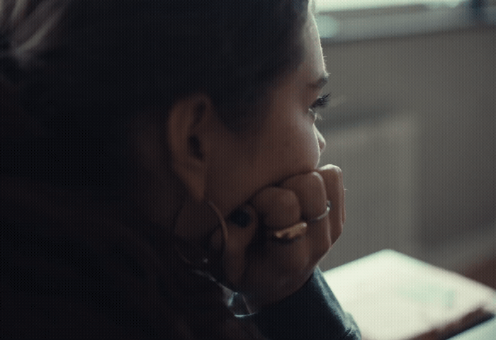 a woman sitting at a table with her hand on her face