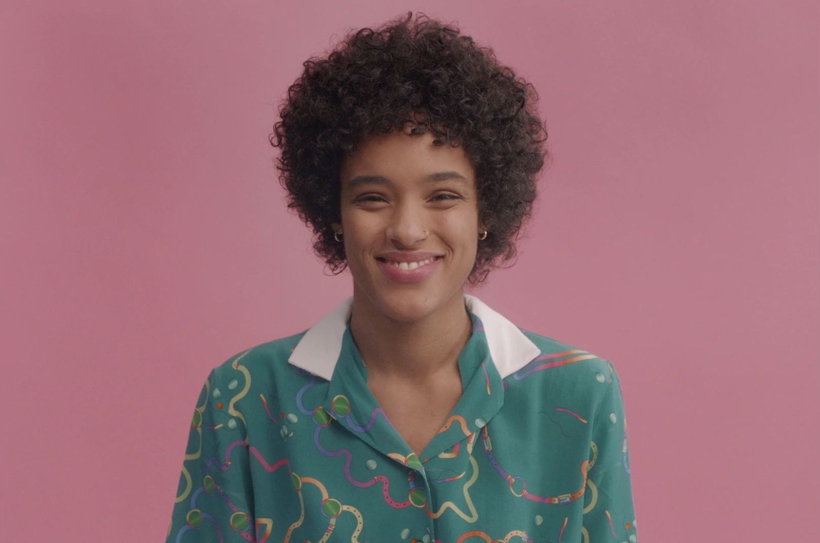 a woman with curly hair wearing a green shirt