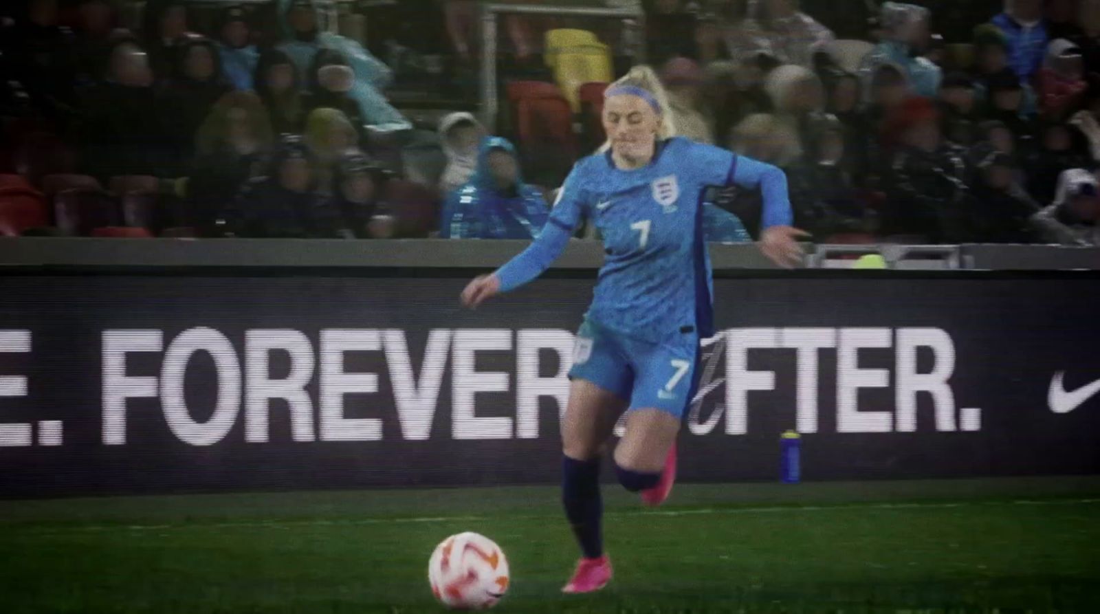 a woman kicking a soccer ball on a field