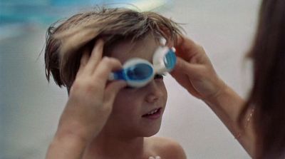 a young boy brushing his hair with a blue and white toothbrush