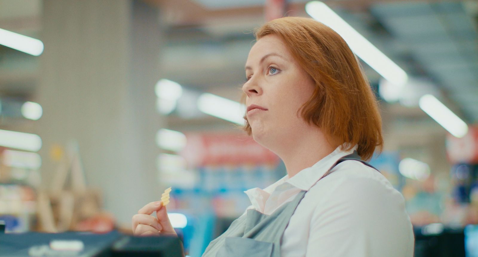 a woman with red hair is holding a piece of food