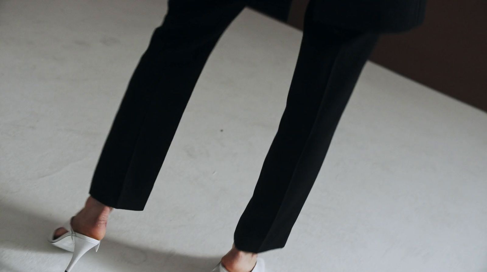 a woman in high heels standing on a bed