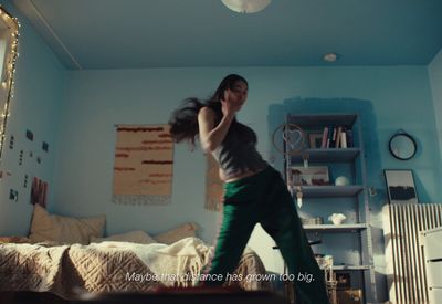 a woman standing in a room with a bed