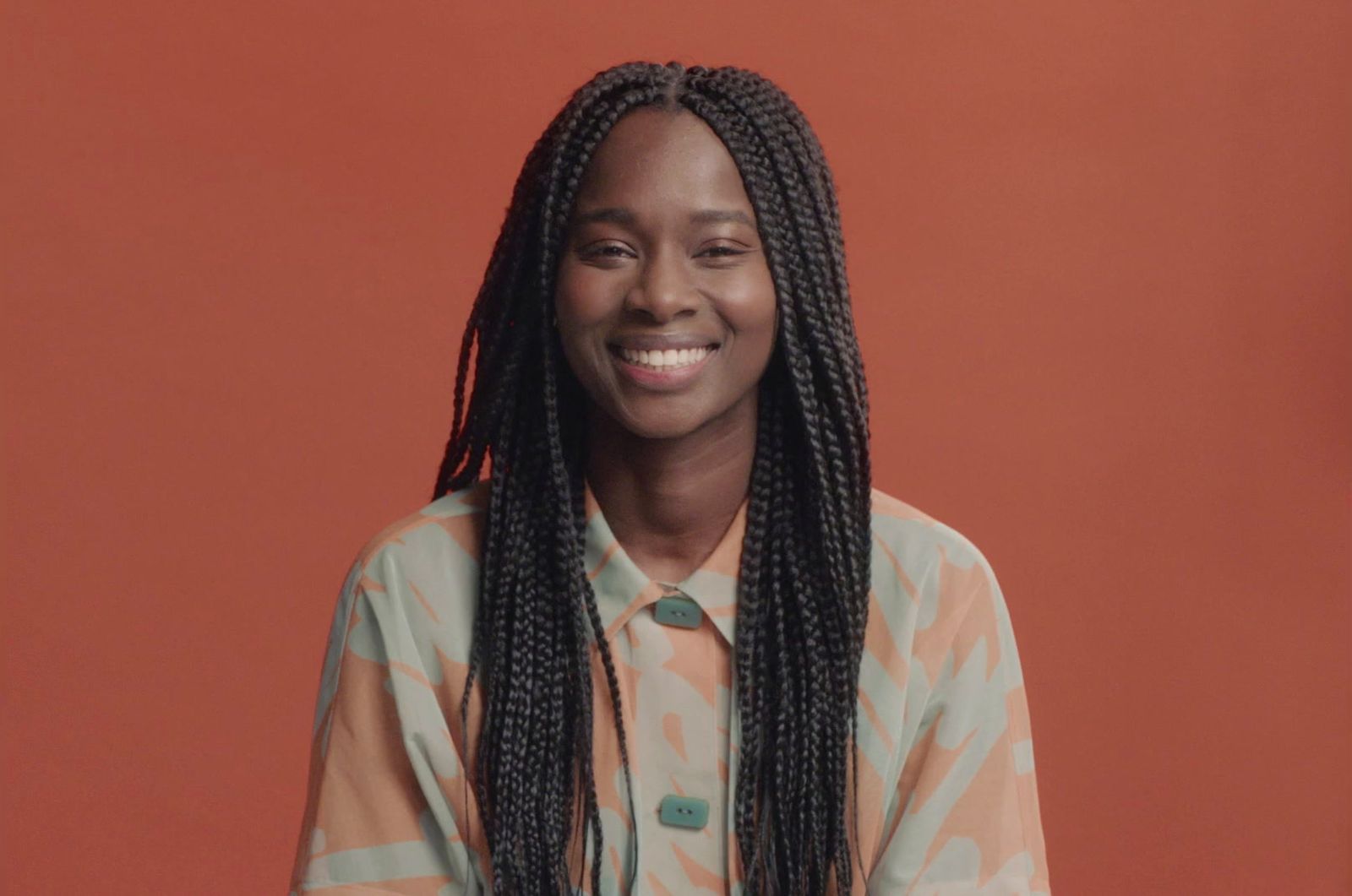 a woman with long braids smiling at the camera