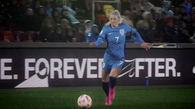 a woman kicking a soccer ball on a field