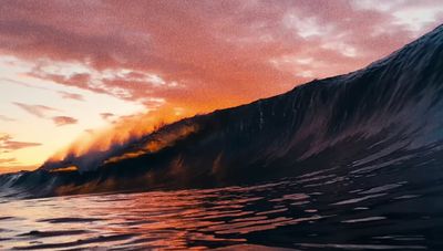 a large wave in the ocean with a sunset in the background