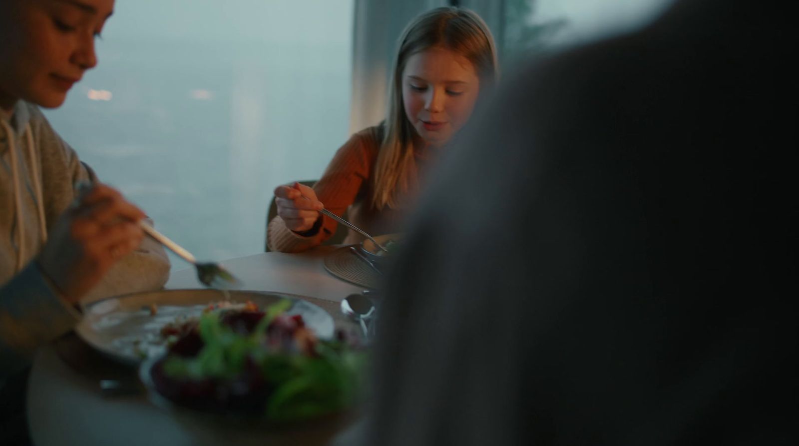 a group of people sitting around a table eating food