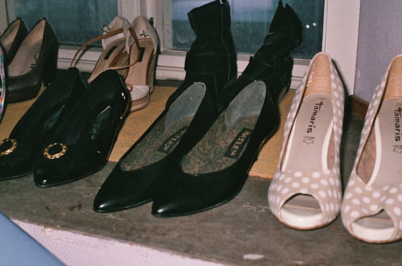 a group of women's shoes lined up on a window sill