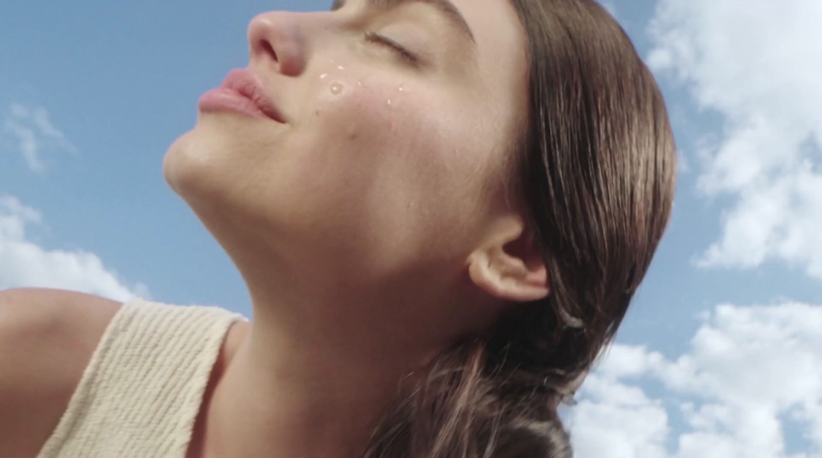 a woman with her eyes closed looking up into the sky