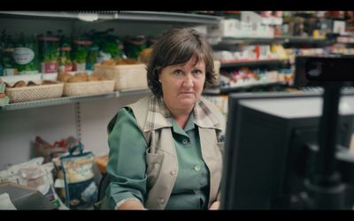 a woman sitting in front of a computer in a store