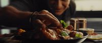 a man eating food from a plate on a table