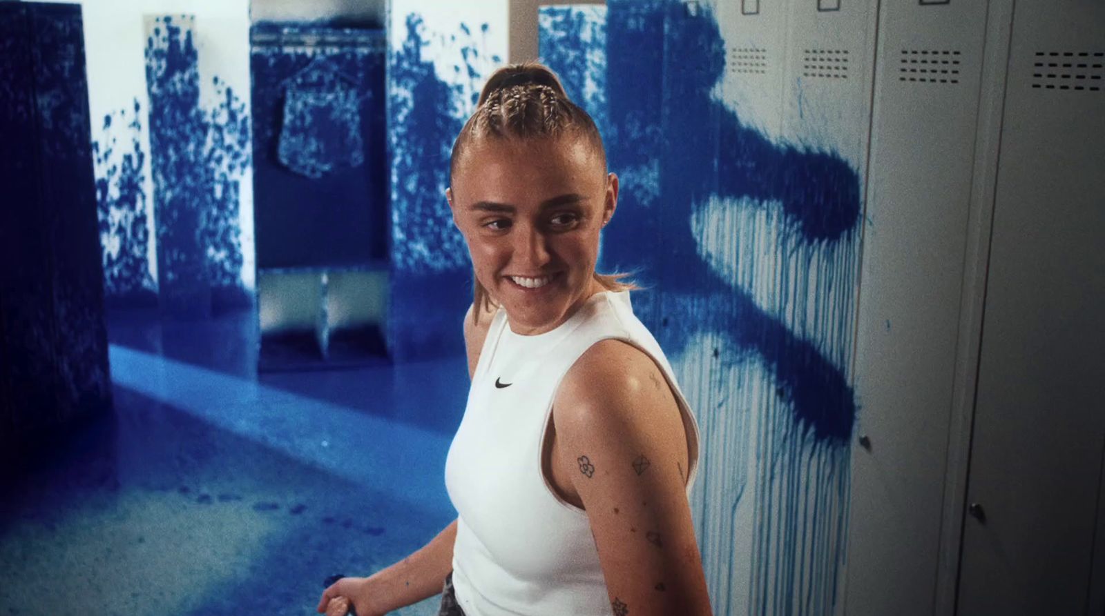 a woman in a white tank top holding a tennis racquet