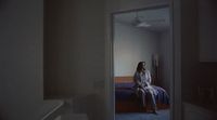 a woman sitting on a bed in a room