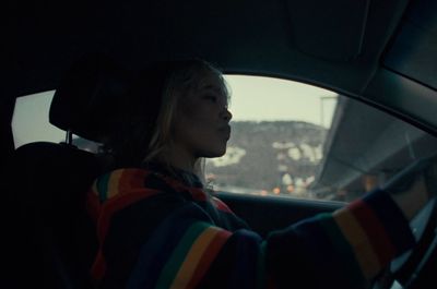 a woman driving a car in the dark