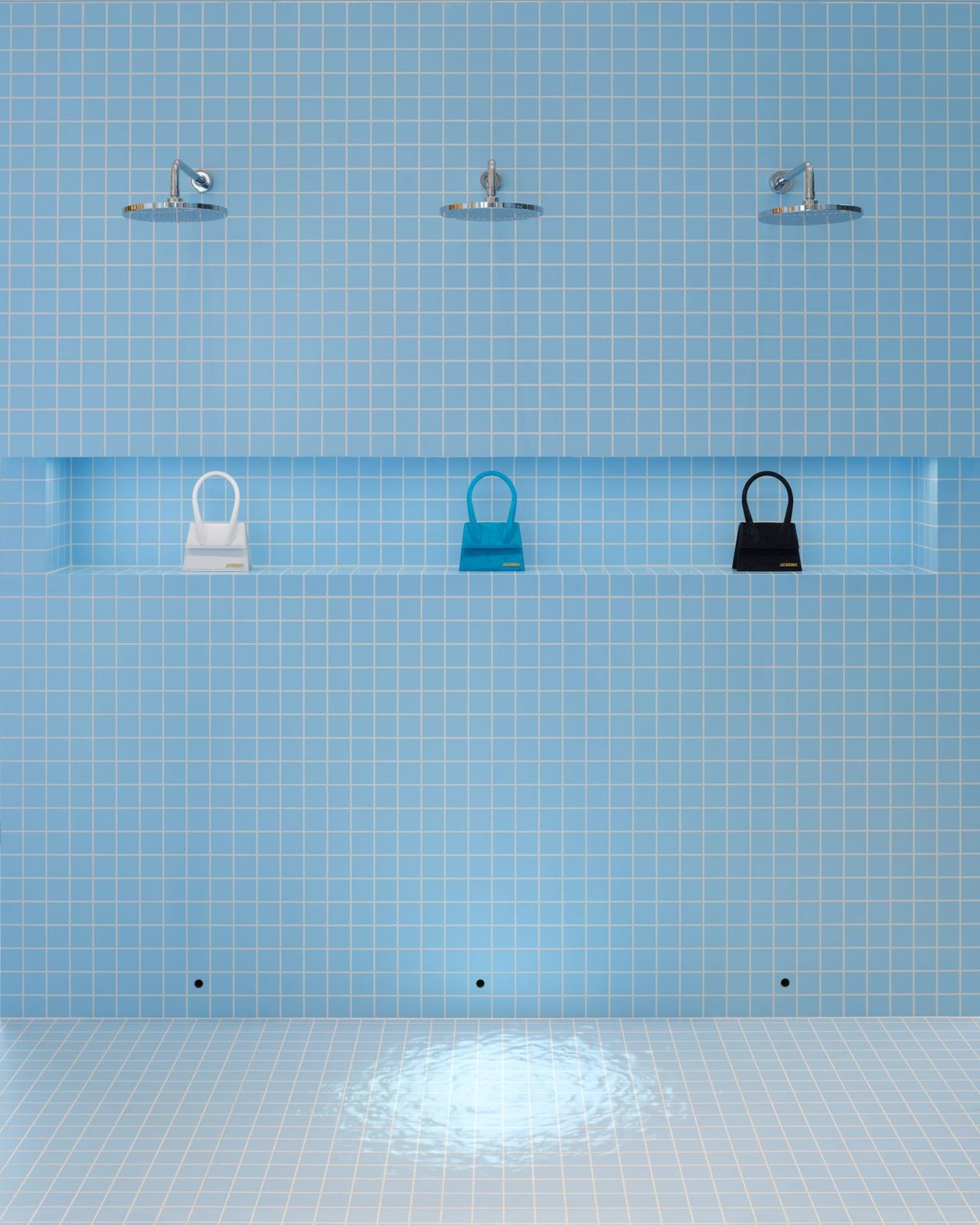 a blue tiled bathroom with a shelf with three purses on it