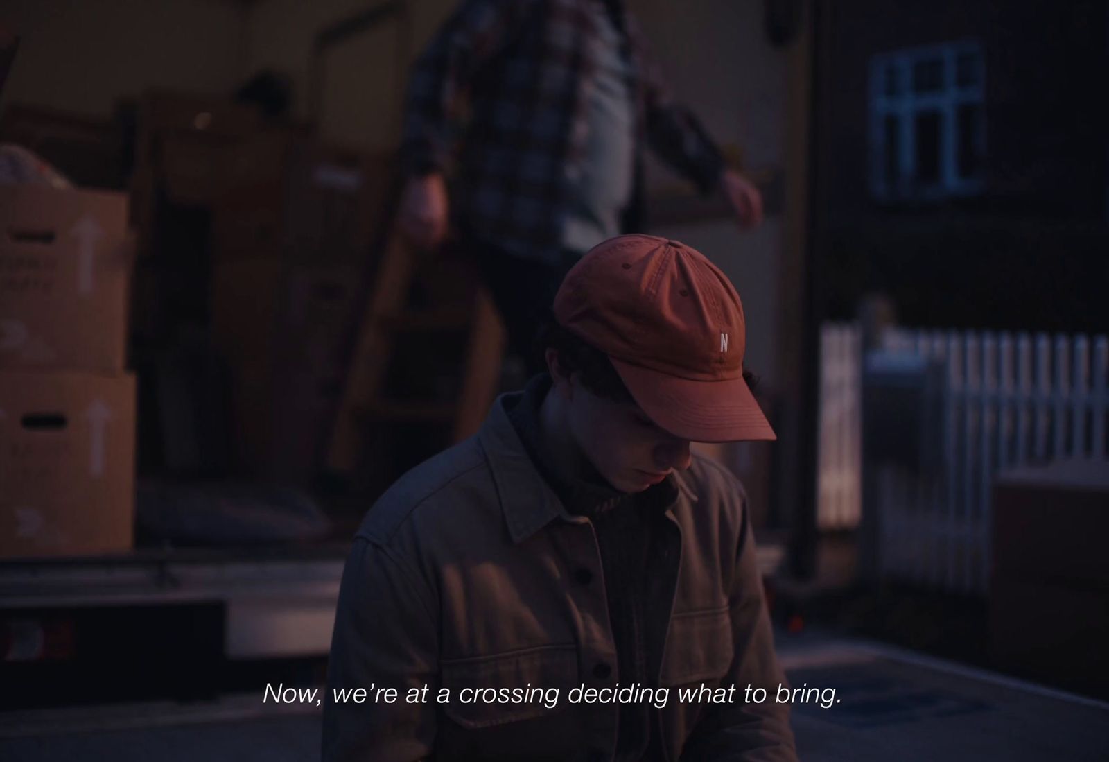 a man in a red hat standing next to a truck