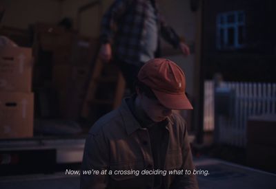 a man in a red hat standing next to a truck