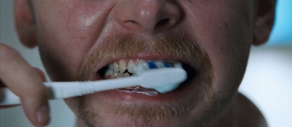 a man brushing his teeth with a toothbrush