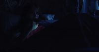 a person sitting in a bed in the dark