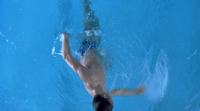 a man swimming in a pool with no shirt on