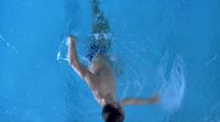 a man swimming in a pool with no shirt on