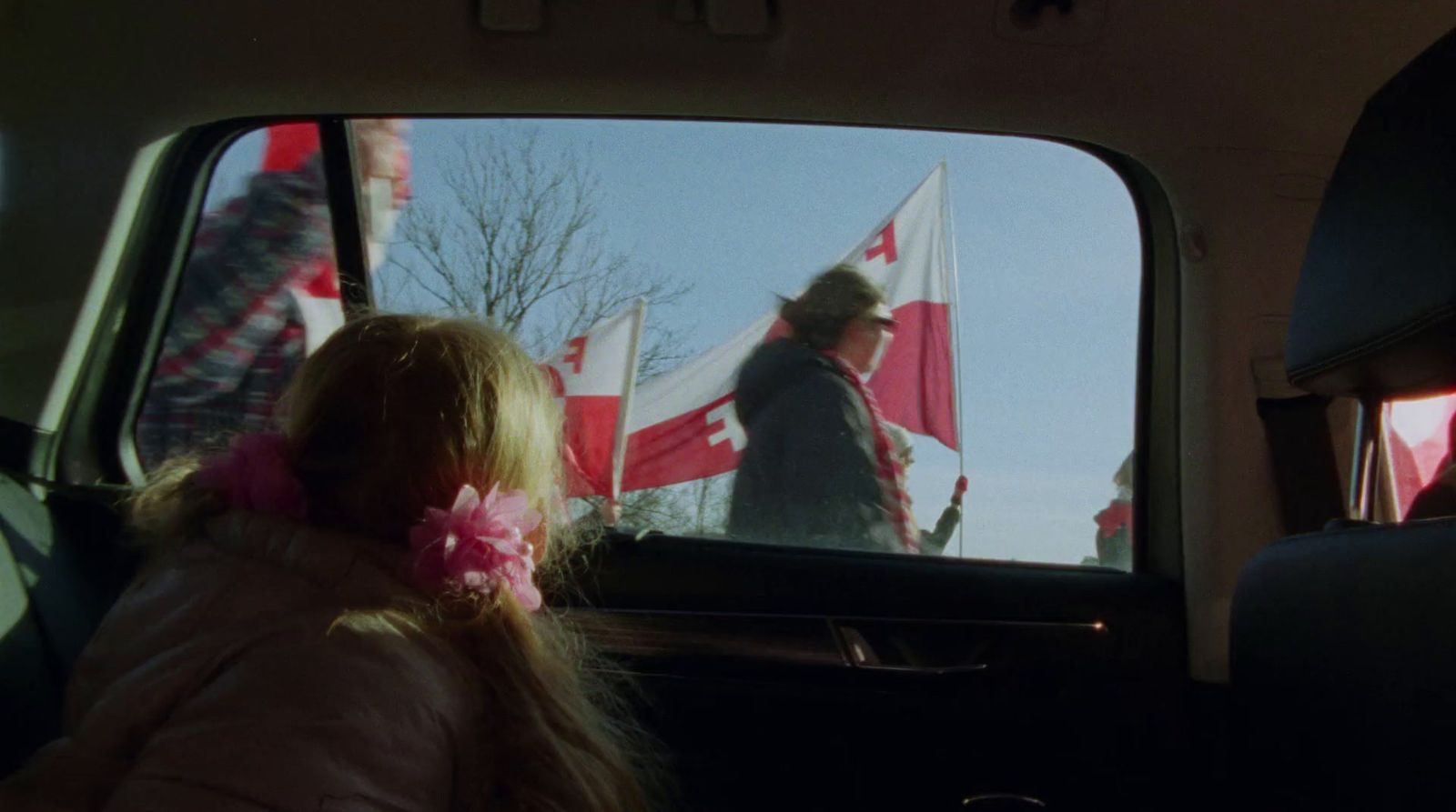 a little girl sitting in the back seat of a car