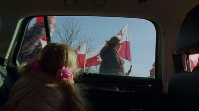 a little girl sitting in the back seat of a car
