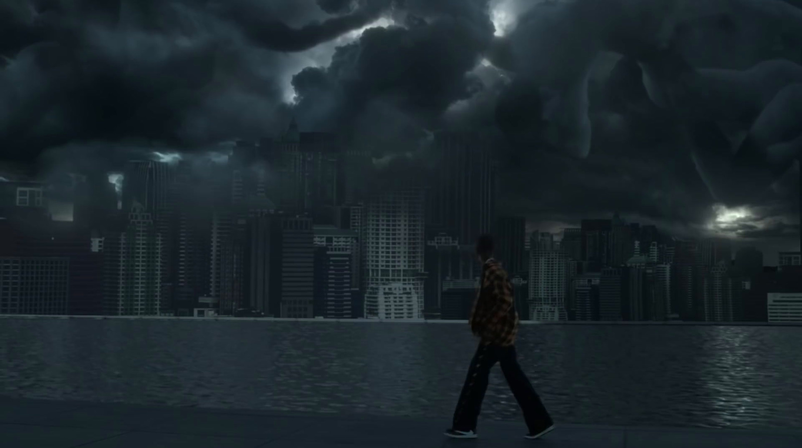 a man walking across a street under a cloudy sky