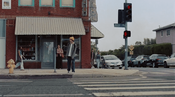 a man walking across a street next to a traffic light