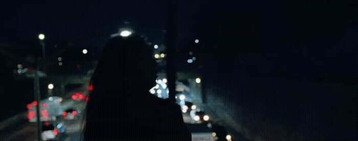 a woman walking down a street at night