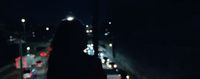 a woman walking down a street at night
