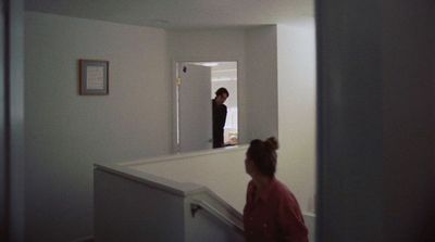 two women standing in a hallway looking at a mirror