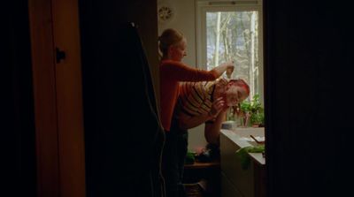 a woman is brushing a child's hair in a kitchen