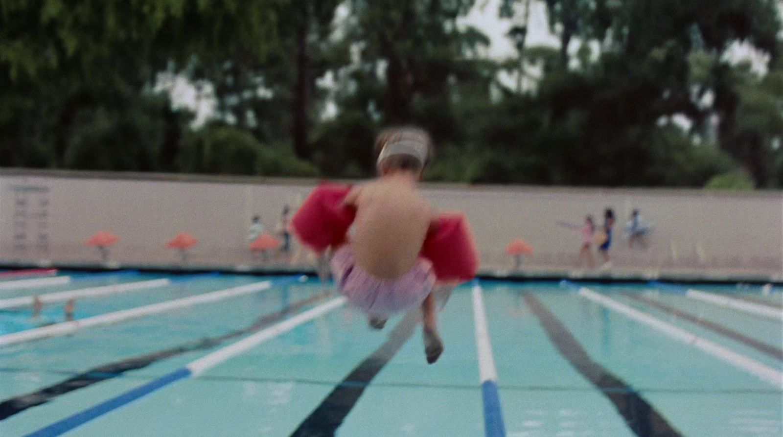 a blurry photo of a person jumping into a swimming pool