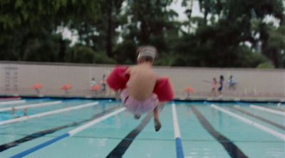 a blurry photo of a person jumping into a swimming pool