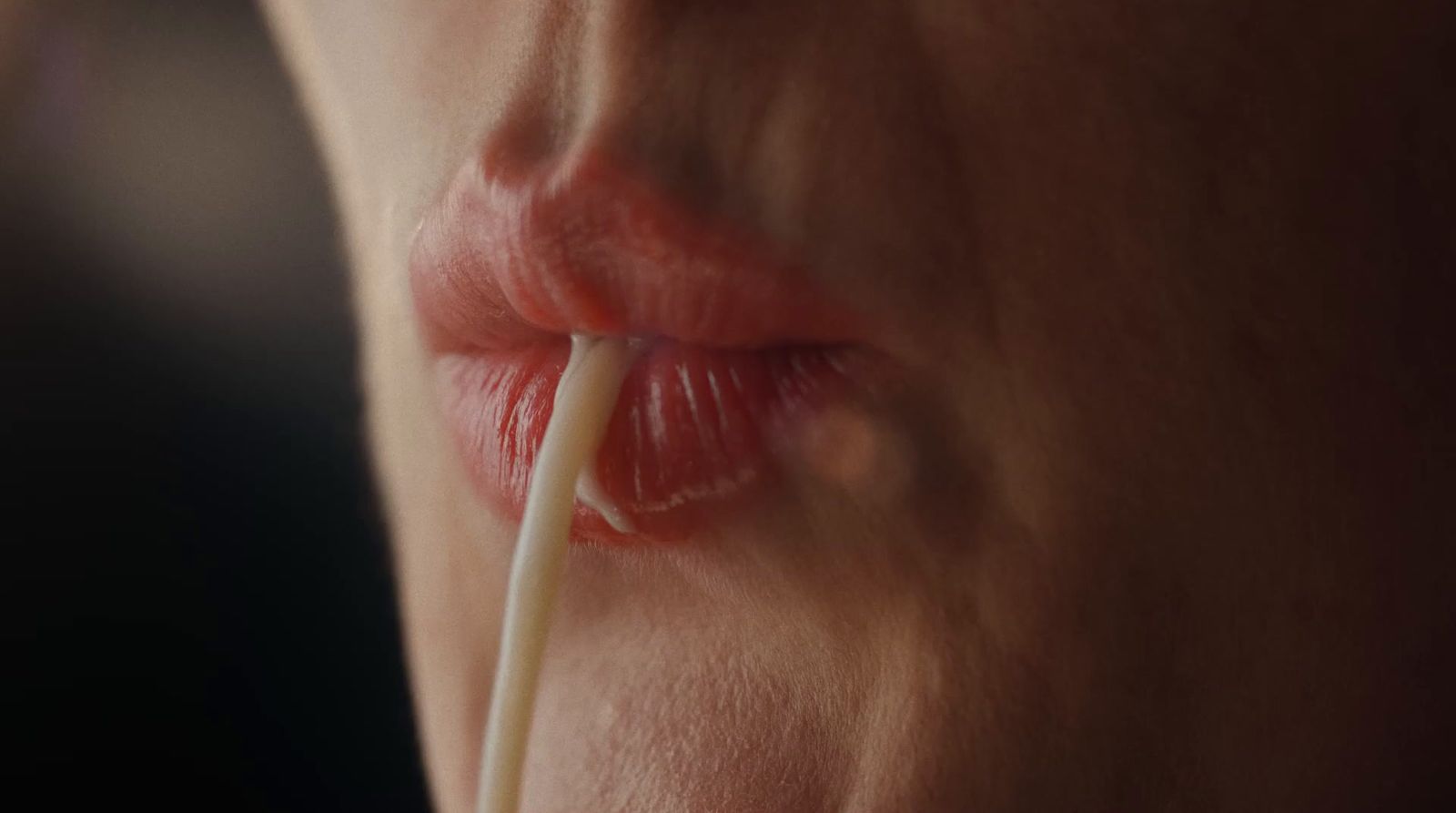 a close up of a woman's lips with a toothpick in her