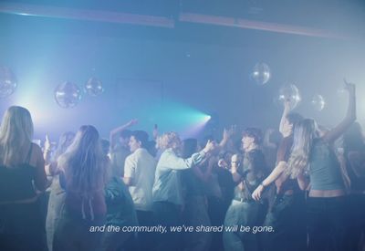 a group of people standing around each other on a dance floor