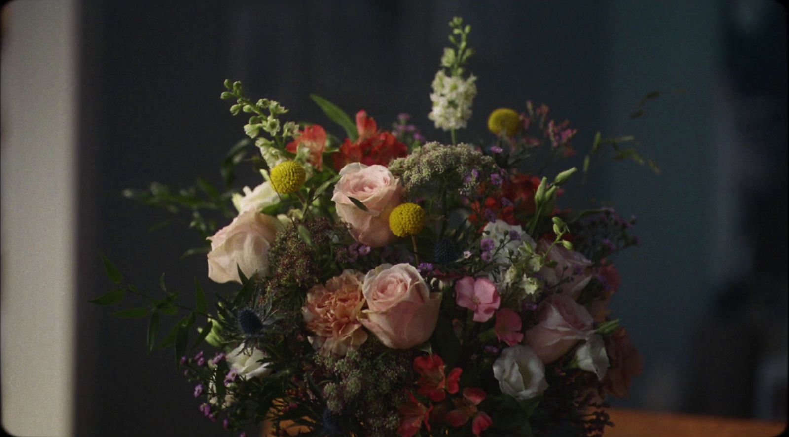 a bouquet of flowers sitting on top of a wooden table