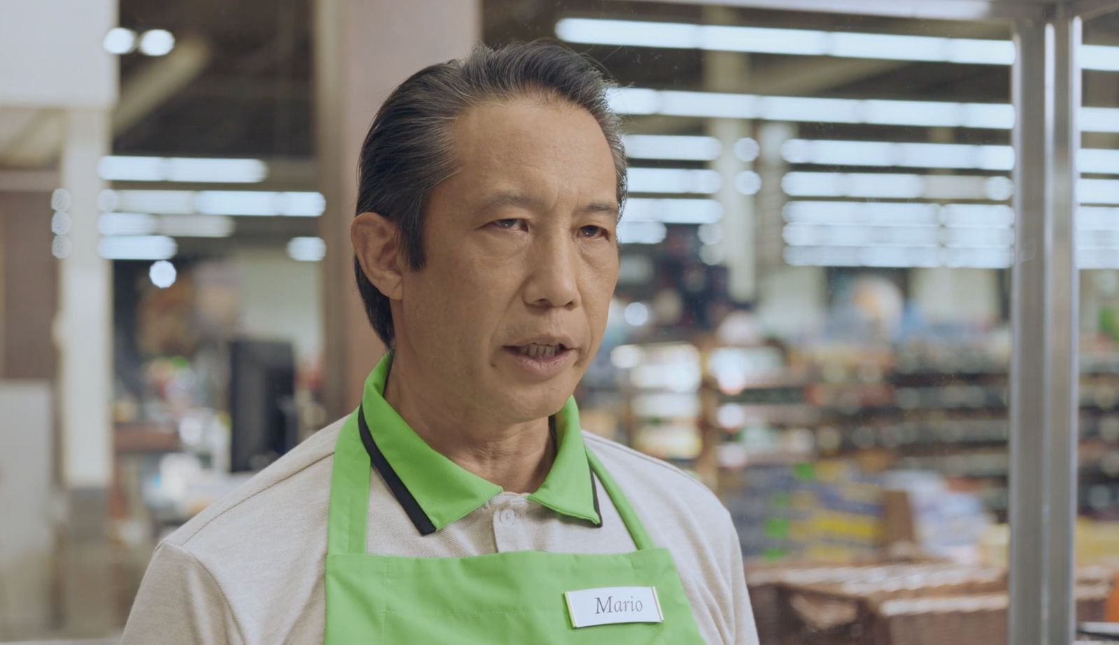 a man wearing a green apron in a store